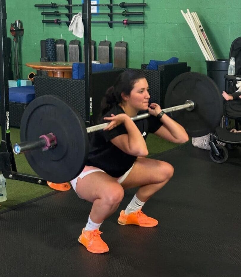 Woman power cleaning a barbell.