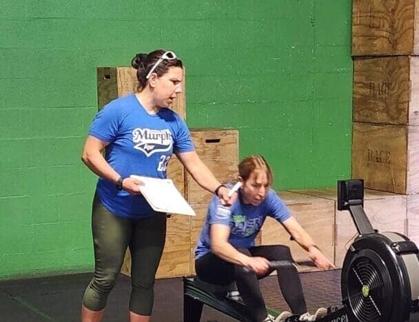 Coach Amanda teaching a female athlete to row.